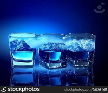 Three glasses of blue liquid with mountain illustration in