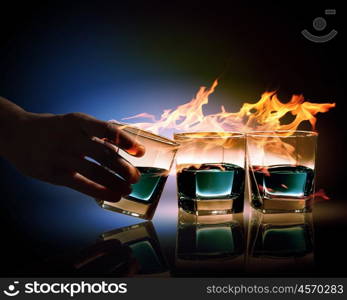 Three glasses of burning emerald absinthe. Image of three glasses of burning emerald absinthe