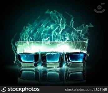 Three glasses of burning emerald absinthe. Image of three glasses of burning emerald absinthe