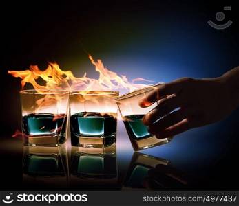 Three glasses of burning emerald absinthe. Image of three glasses of burning emerald absinthe