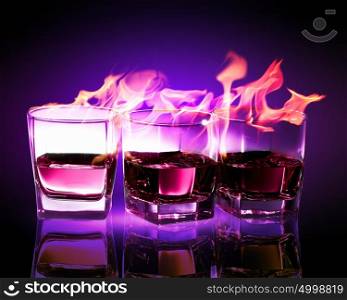 Three glasses of burning purple absinthe. Image of three glasses of burning puple absinthe