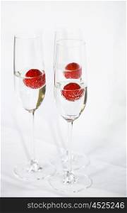 Three glasses of champagne cocktails against a white backdrop