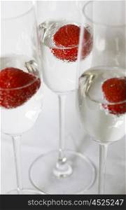 Three glasses of champagne cocktails against a white backdrop