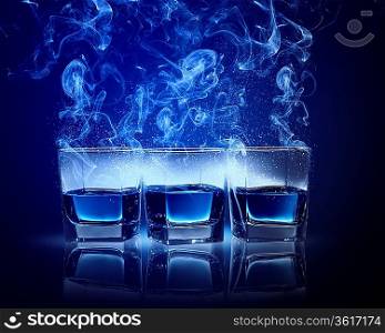 Three glasses of cocktail with fumes and falling snow