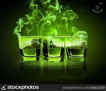 Three glasses of green absinth. Three glasses of green absinth with nature illustration in