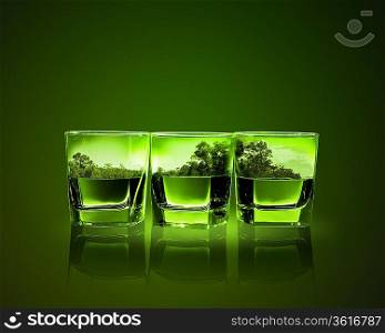 Three glasses of green absinth with nature illustration in