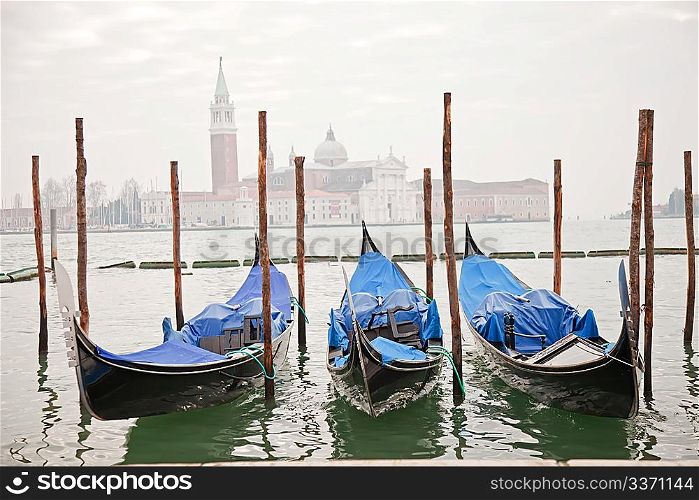 Three gondolas in Venice at the pier
