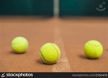 three green tennis balls tennis court