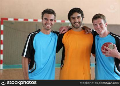 Three grinning footballers in front of goal