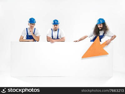 Three handsome craftsmen holding the empty white board