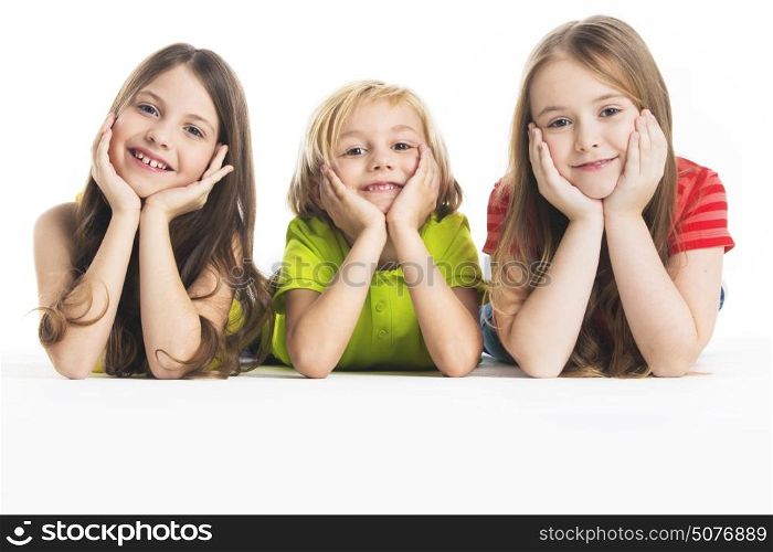 Three happy children. Three happy children laying down, isolated on white background
