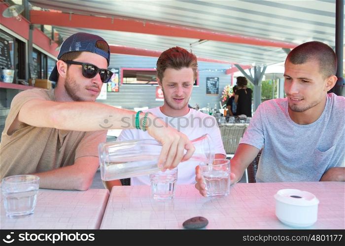 three happy friends drink water to quench their thirst