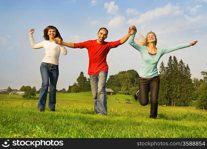 Three happy friends running outdoors