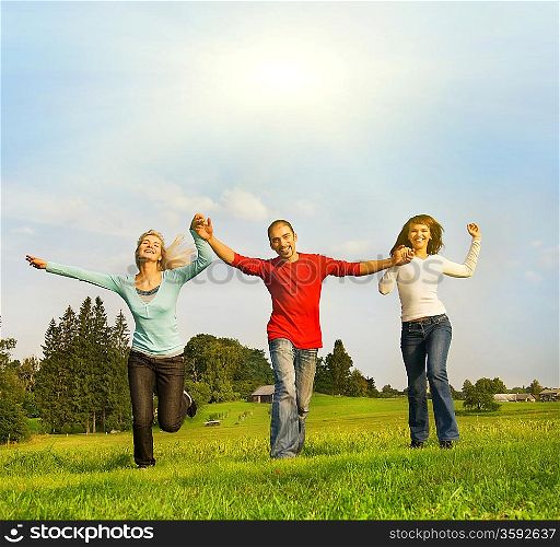 Three happy friends running outdoors