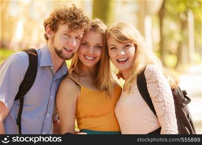 Three happy smiling young people friends outdoor. Attractive women and handsome man portrait. Summer vacation.. Three happy young people friends outdoor.