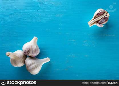 Three heads and cloves of the garlic on a wooden table. Spice. Food background. The concept of healthy food.. Three heads and cloves of the garlic on a wooden table