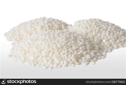 Three heaps of fine white polymer granules isolated on white background