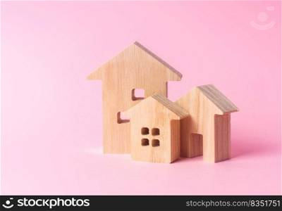 Three houses on a pink background. Buying and selling of real estate, construction. Apartments and residential buildings in a city or settlement. Investments. mortgage loan. Housing Maintenance