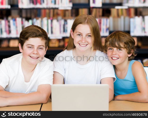 Three kids in library with notebook. Three kids in library