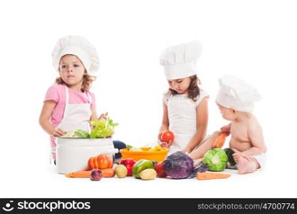 Three kids play with vegatables. Little chefs isolated on white. Little chefs cook