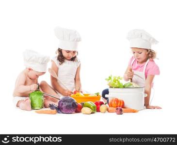 Three kids play with vegetables. Little chefs isolated on white. Little chefs cook