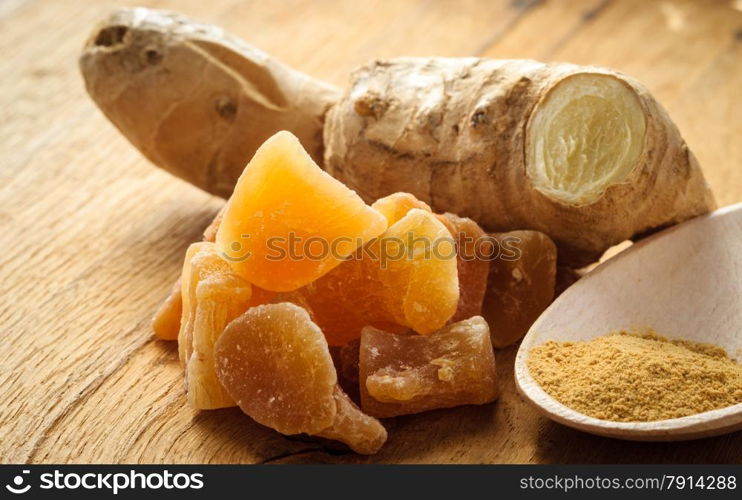 Three kinds of ginger - ground spice fresh and candied on rustic table. Healthy eating, home remedy for nausea upset stomach colds.