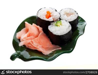 Three kinds of sushi with ginger on a leaf shaped plate. Shot on white background.
