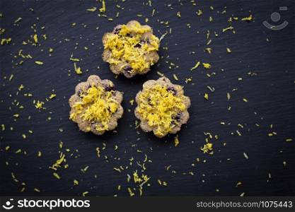 Three lemon cupcakes on a black background. lemon cupcakes on a black background