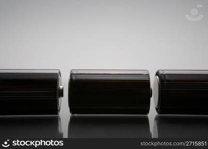 Three LR20 alkaline batteries on a reflective studio background