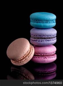 Three macaroon each other and one next on black background. Colorful macaroon each other and one next