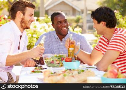 Three Male Friends Enjoying Meal At Outdoor Party