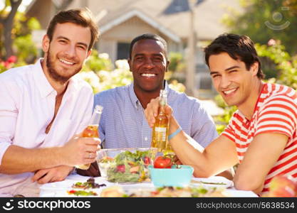 Three Male Friends Enjoying Meal At Outdoor Party