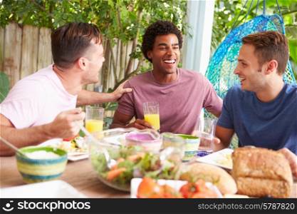 Three Male Friends Enjoying Meal Outdoors At Home
