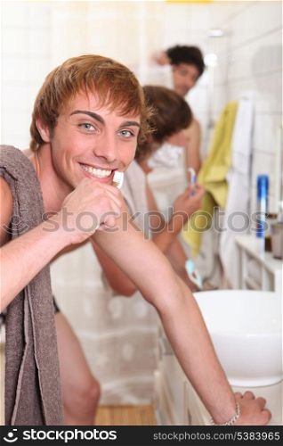 Three male housemates in bathroom
