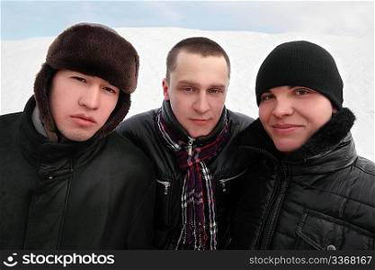 three man in black dress standing together and looking at camera, winter day
