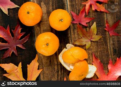 Three mandarins with autumn leaves, season?s fruit