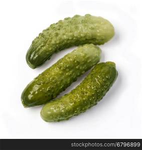 three marinated pickled cucumbers isolated on white