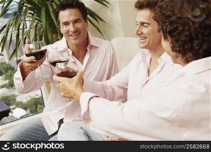 Three mature men toasting a drink