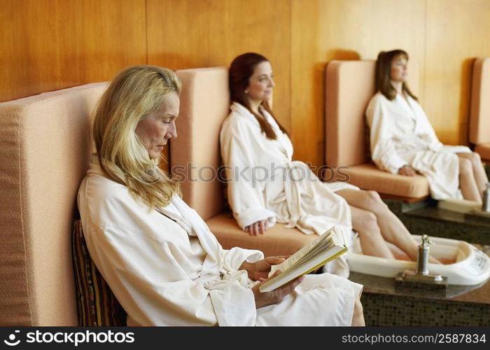 Three mature women getting pedicure in a beauty parlor