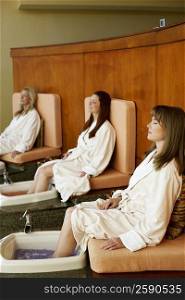 Three mature women getting pedicure in a beauty parlor