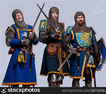 Three medieval knights isolated on grey background.