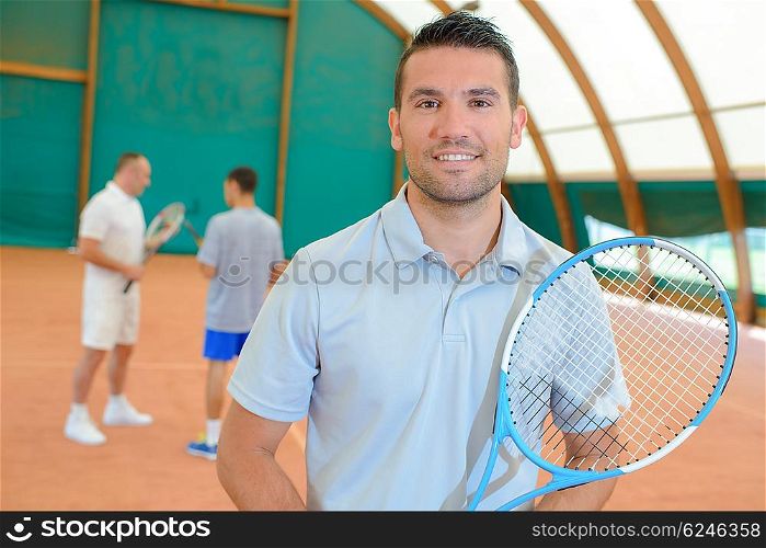 three men in the tennis court