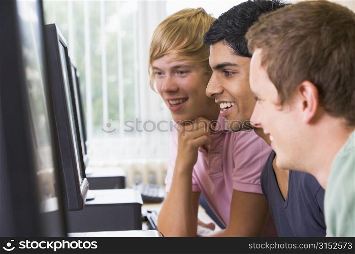 Three men sitting at a computer terminal (high key)