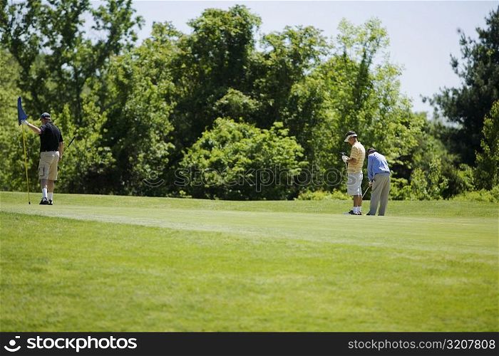 Three men standing on a golf course