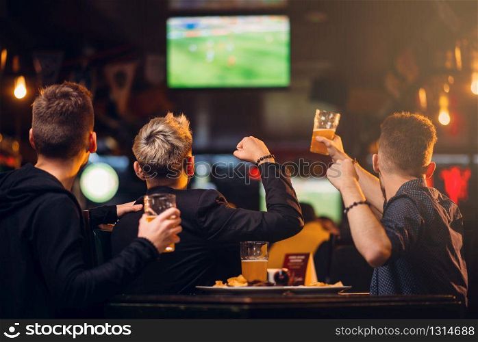 Three men watches football on TV in a sport bar, happy leisure of fan company