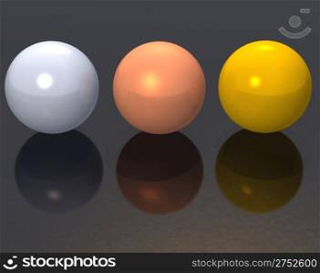 Three metal spheres - gold, bronze, silver - on a black surface