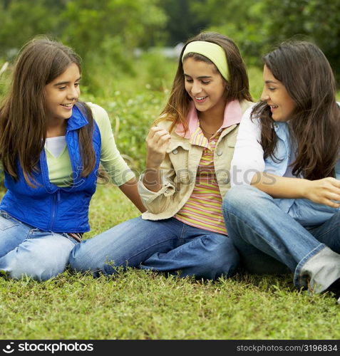 Three mid adult women sitting on a lawn