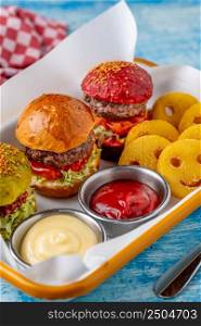 three mini burgers with chicken and meat served with french fries. kids menu
