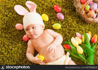 Three months baby lying on on the grass carpet as a Easter bunny. Baby Easter bunny