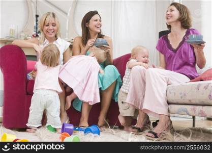 Three mothers in living room with coffee and babies smiling